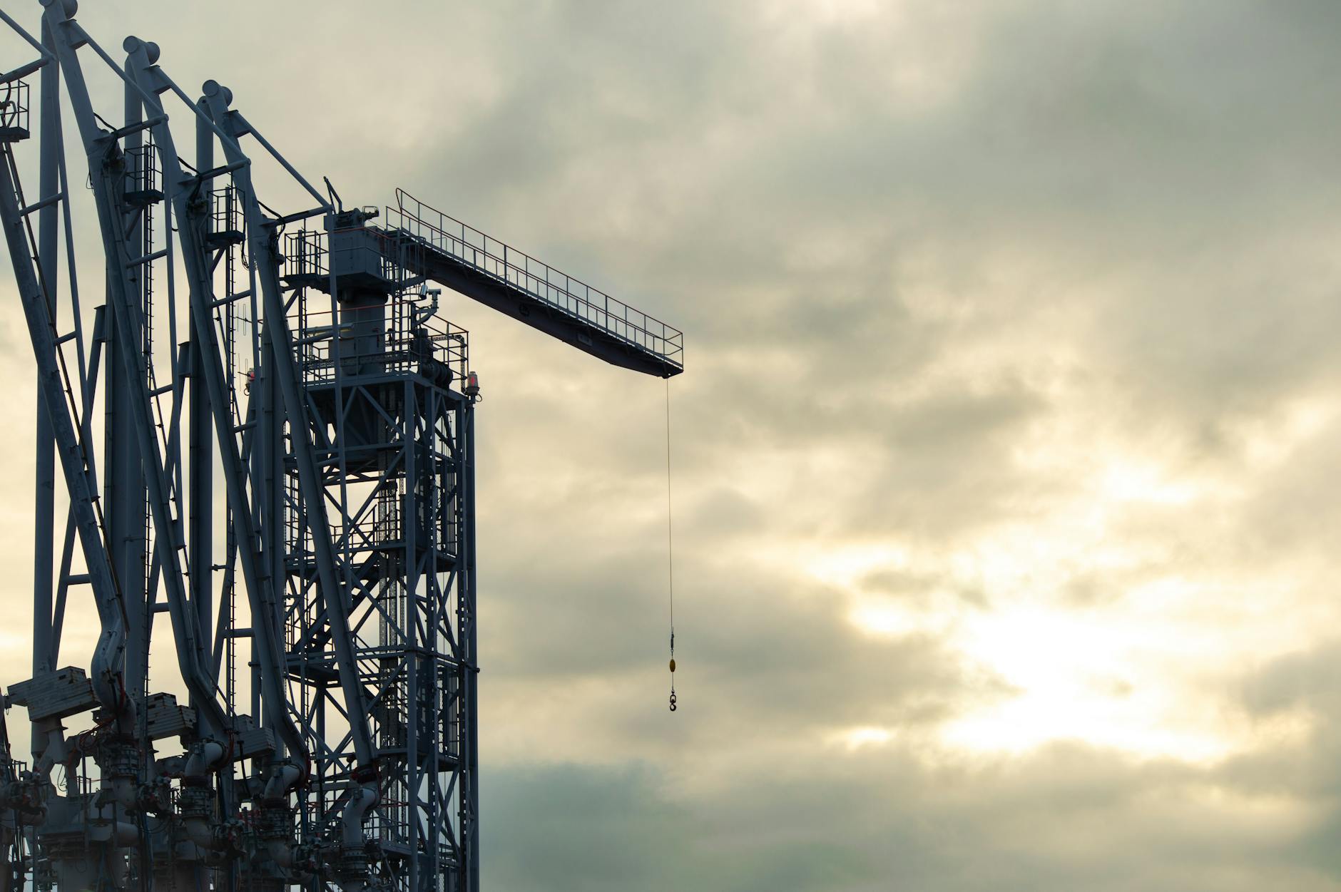 industrial crane at sunset with cloudy sky